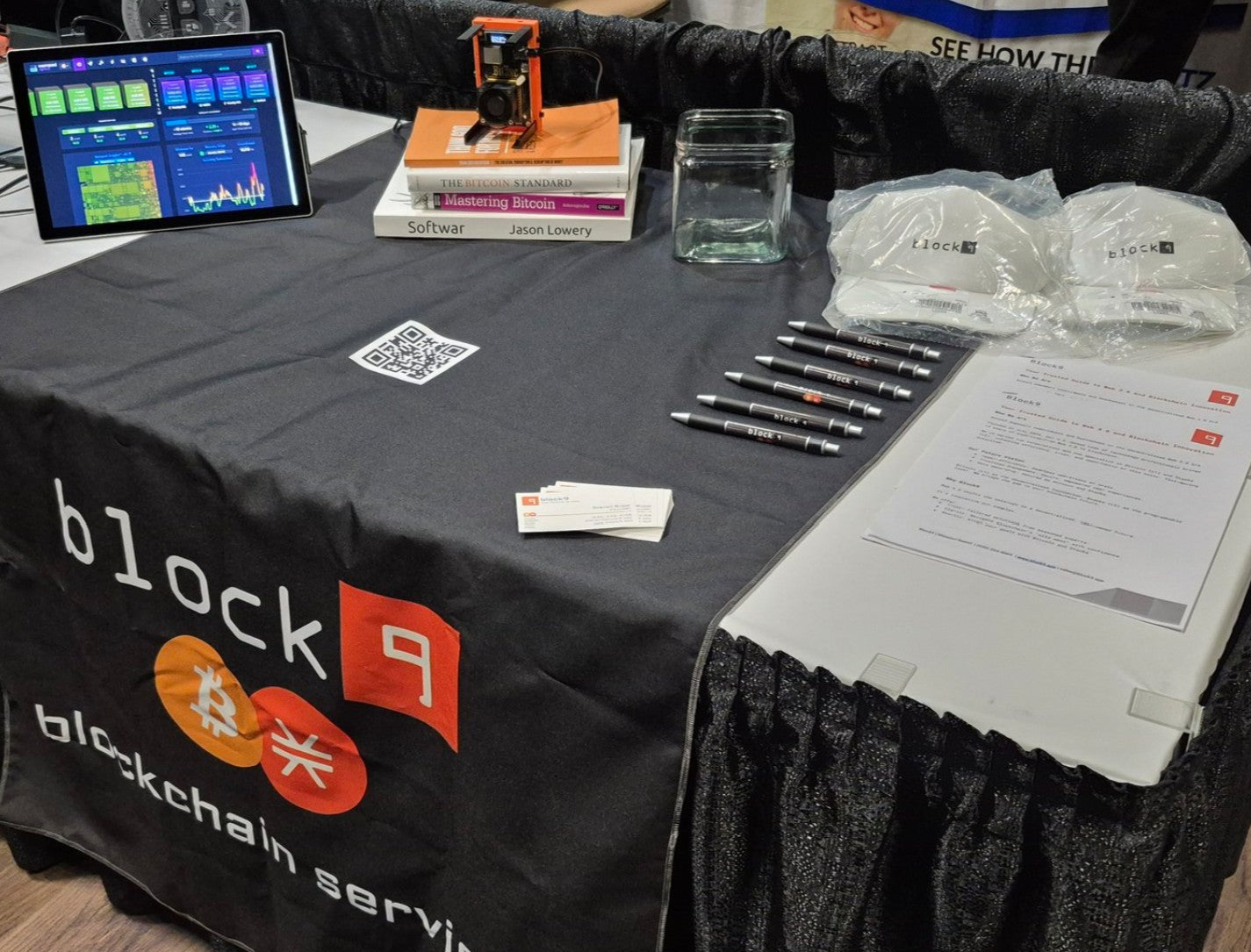 Steven of Block9 at a conference in an orange Block9 shirt, orange case at his side