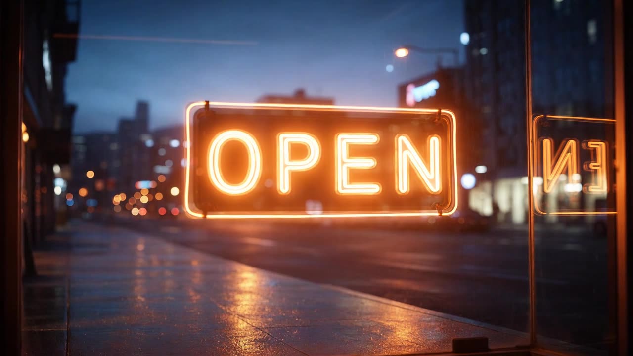 An OPEN sign in a shop window, lighting orange against a wet night street